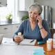 A patient organizing medications and appointments while speaking with a nurse by phone