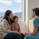 Parent and child speaking with a pediatric care professional in a bright Calgary clinic