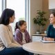 Parent and child speaking with a pediatric care professional in a bright Hamilton clinic