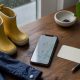 Small rain boots, a phone and a blank appointment card arranged for a Vancouver pediatric care search