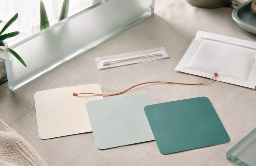 Abstract paper version cards and a sealed screening kit envelope in a calm clinic palette